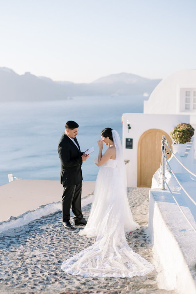 wedding couple reading vows to each other at sunrise on the island of santorini